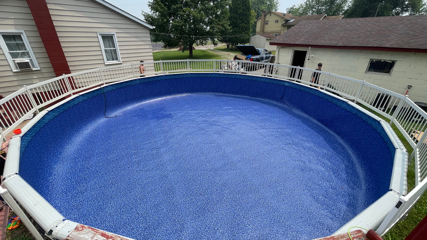 Circular aboveground pool with a wooden deck and fences