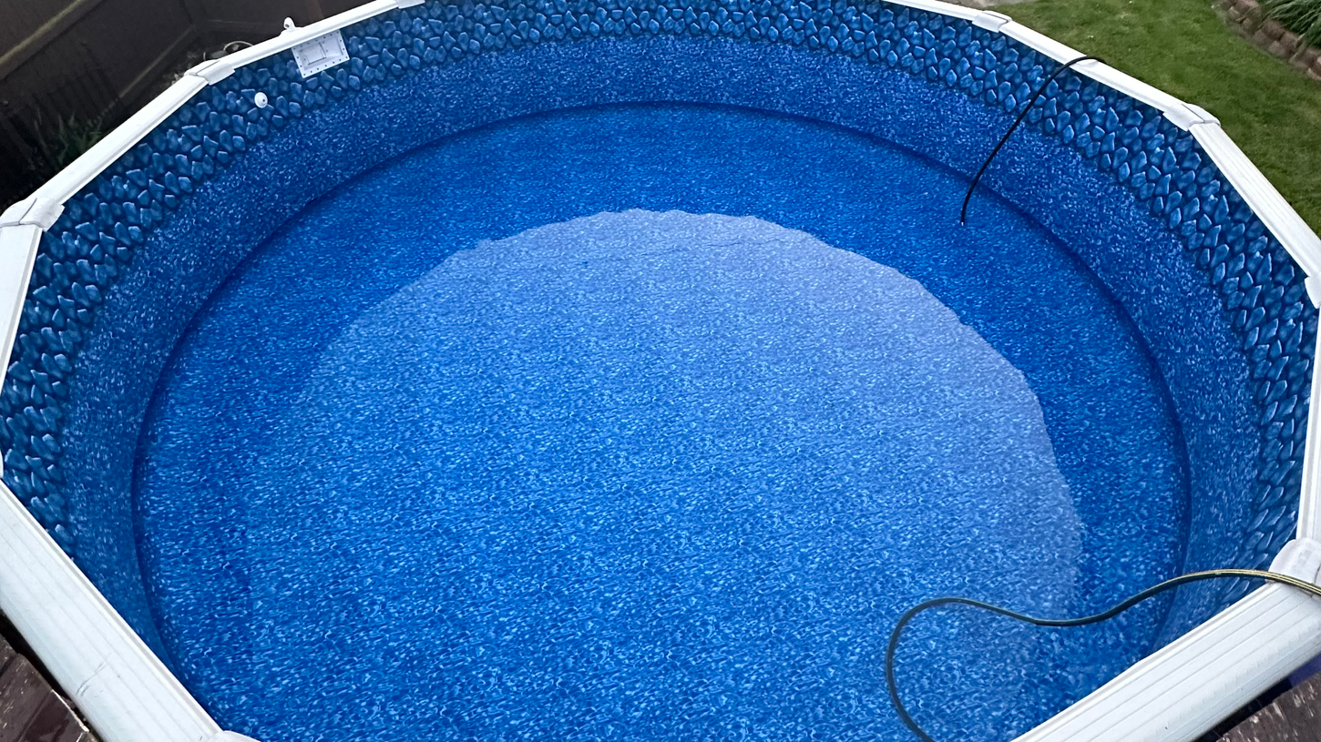 Circular aboveground pool with a wooden deck in a backyard
