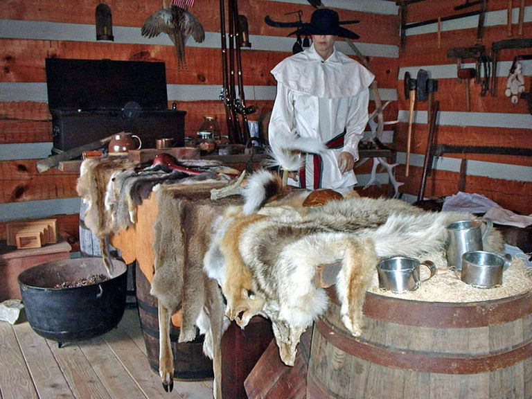 Table with animal skins with a mannequin in the back