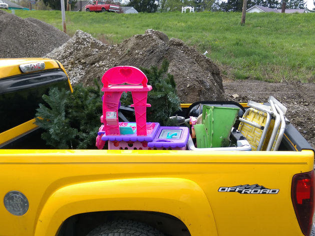 Yellow pickup truck carrying various recyclables