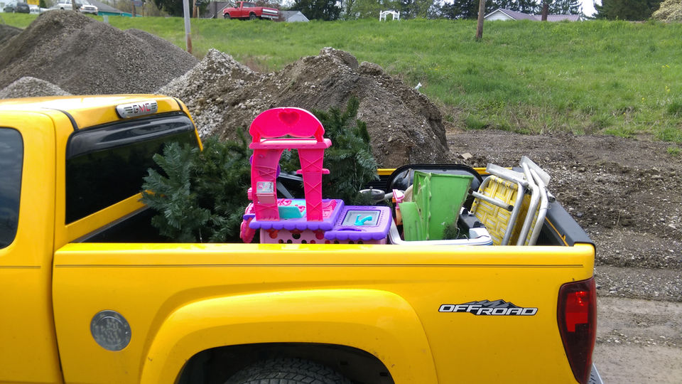Yellow pickup truck carrying various recyclables