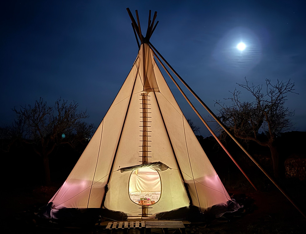 Glowing teepee under a full moon at a conscious retreat in Mallorca