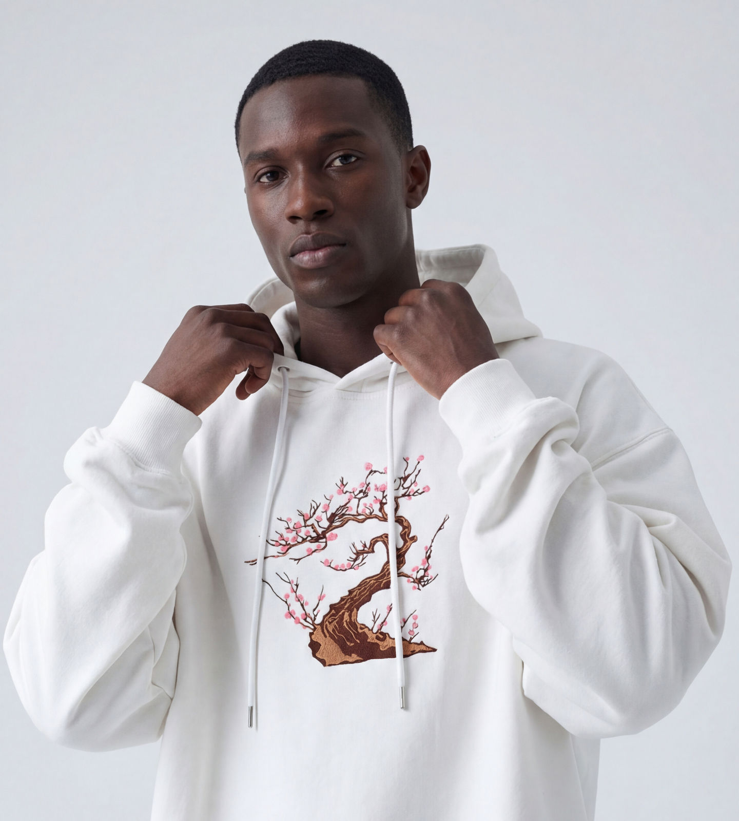 Man in white hoodie with tree design