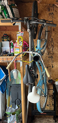 light blue bike hung vertically in a shed