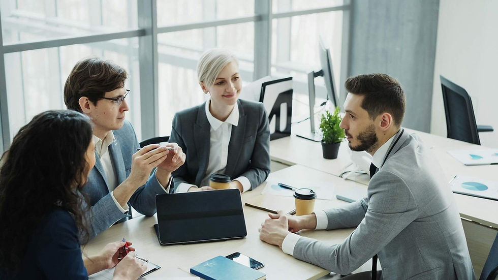 Colleagues discussing plans around a table during a business meeting.