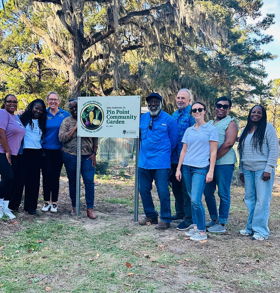 Members of the Pin Point Betterment Association and Georgia Tech's CEAR Hub gather for a group photo by the new sign at the Pin Point Community Garden during its ribbon-cutting ceremony.