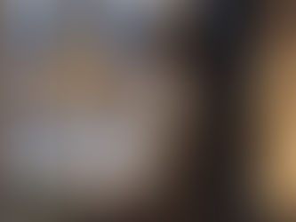 A person stands quietly at the edge of a holiday gathering, surrounded by conversation and lights, while appearing emotionally distant and disconnected.