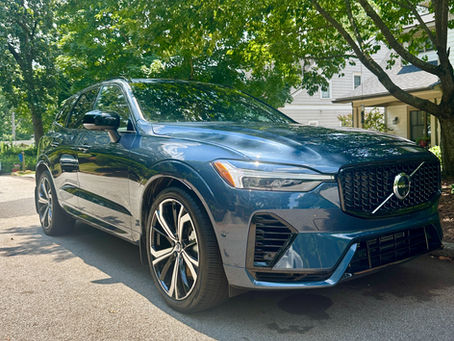 Shiny, freshly detailed car reflecting sunlight, free of pollen and dust, parked outdoors on a bright spring day.