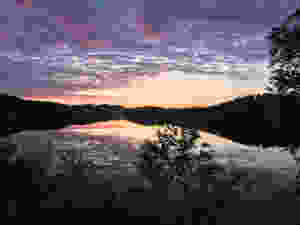 Purple and orange sky of a sunrise reflected on the calm water