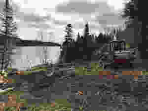 A mini excavator with a buster was used to break apart the rock on our DIY cabin build lot