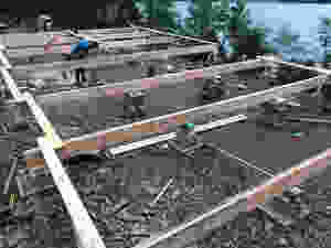 In the photo below you can see our stacking materials which are a combination of cinder blocks, lumber, and in some cases telephone poles placed vertically (like the one Mike is working on in the photo.