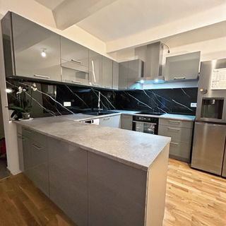 U-Küche in Grau mit glänzenden Fronten und schwarzer Rückwand