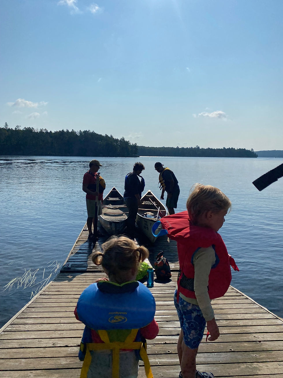 A family gathers together on a dock around their canoes at Lake Opeongo as they prepare to embark on a day trip.