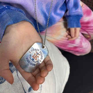 tie dye sweatshirt, tie dye pants, hand holding a medal with the race name and distance