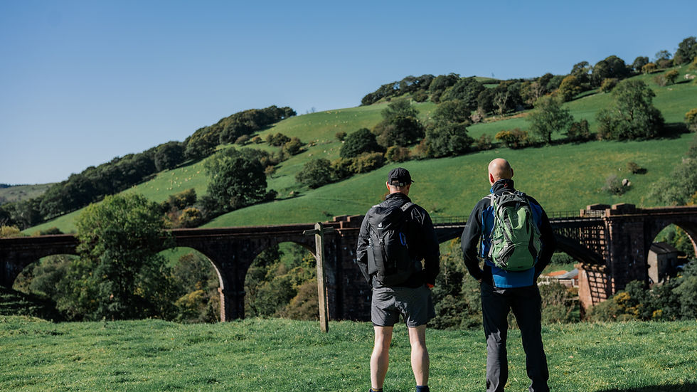 Two men walking side by side in conversation on a countryside trail