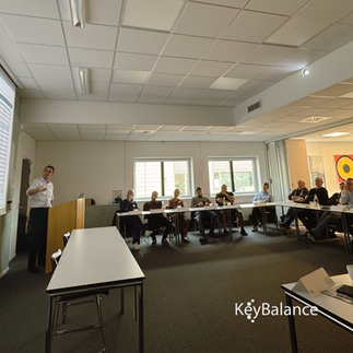 Mennesker sidder omkring en mand der står op