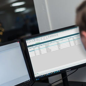 Computerskærm med software åben i et mørkt kontormiljø
