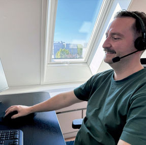 Medarbejder med headset arbejder ved en computer