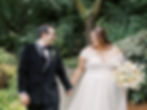 Bride and groom smiling at each other in garden