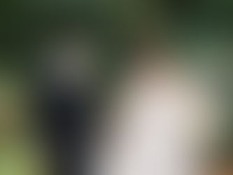 A bride and groom walk through a garden path