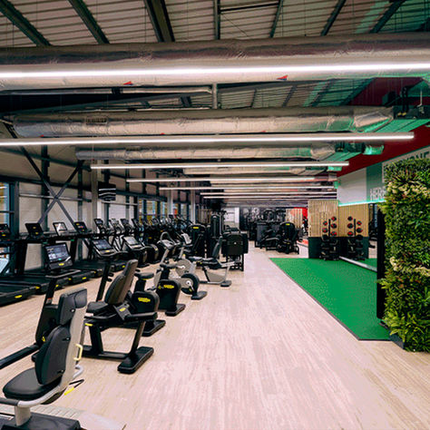 A modern gym in Swanley with black cardio machines and a wooden floor