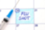 Reminder Flu Shot in calendar with syringe. Close up.