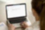 A woman composing an email on a laptop