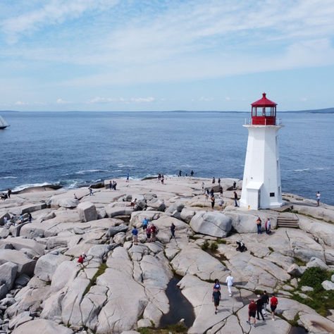 Private Peggy's Cove tour from Halifax — group posing at the lighthouse on a bright October morning