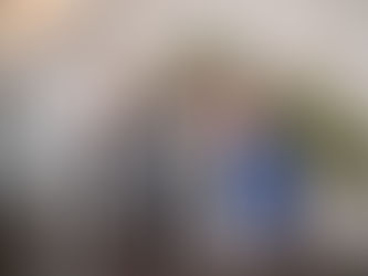 Wedding guests posing together and blowing kisses in front of a professional photo booth setup with floral decorations.