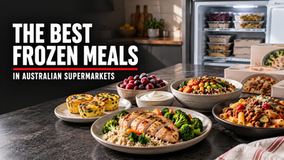 Healthy frozen meal options arranged beside a stocked freezer, including high-protein breakfast, lunch and dinner choices.