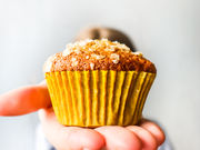 Golden banana muffins topped with oats and served fresh from the oven