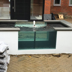 A small raised pond with water spout