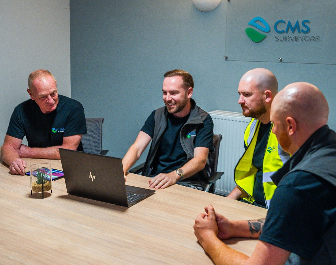 CMS team having a meeting around the laptop