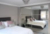 Lavish bedroom reflected in mirrored wardrobe doors