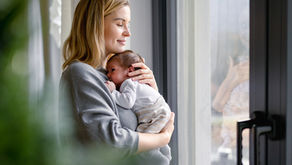 Solomutter mit ihrem Neugeborenen am Fenster – Kinderwunsch mit Samenspende und Begleitung mit Akupunktur und TCM