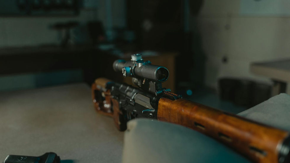 Close-up view of a sniper rifle with a scope on display indoors, suitable for military or hunting themes.