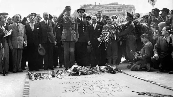 Le Général de GAULLE dépose une gerbe sur la tombe du soldat inconnu avant de descendre à pied l'avenue des Champs-Elysées (Crédit : STF/AFP).