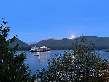 A cruise ship slips through the Tongass Narrows, as the moon rises above mountains on Gravina Island, near Ketchikan.
