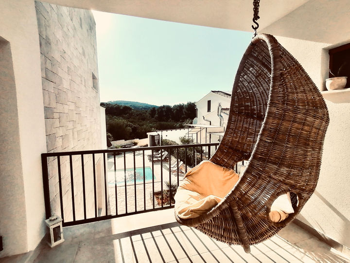 Korbhängesessel mit Blick auf den Pool