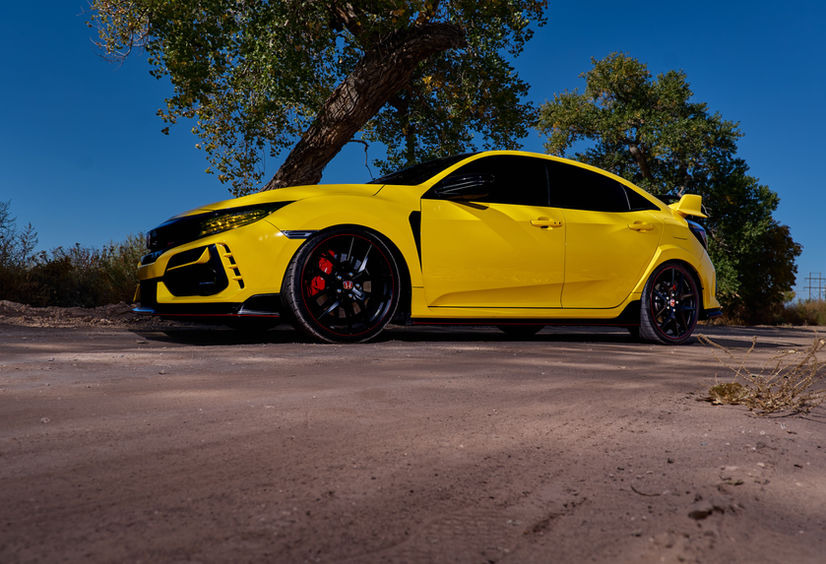 Honda Type R in front of trees on a dirt road.