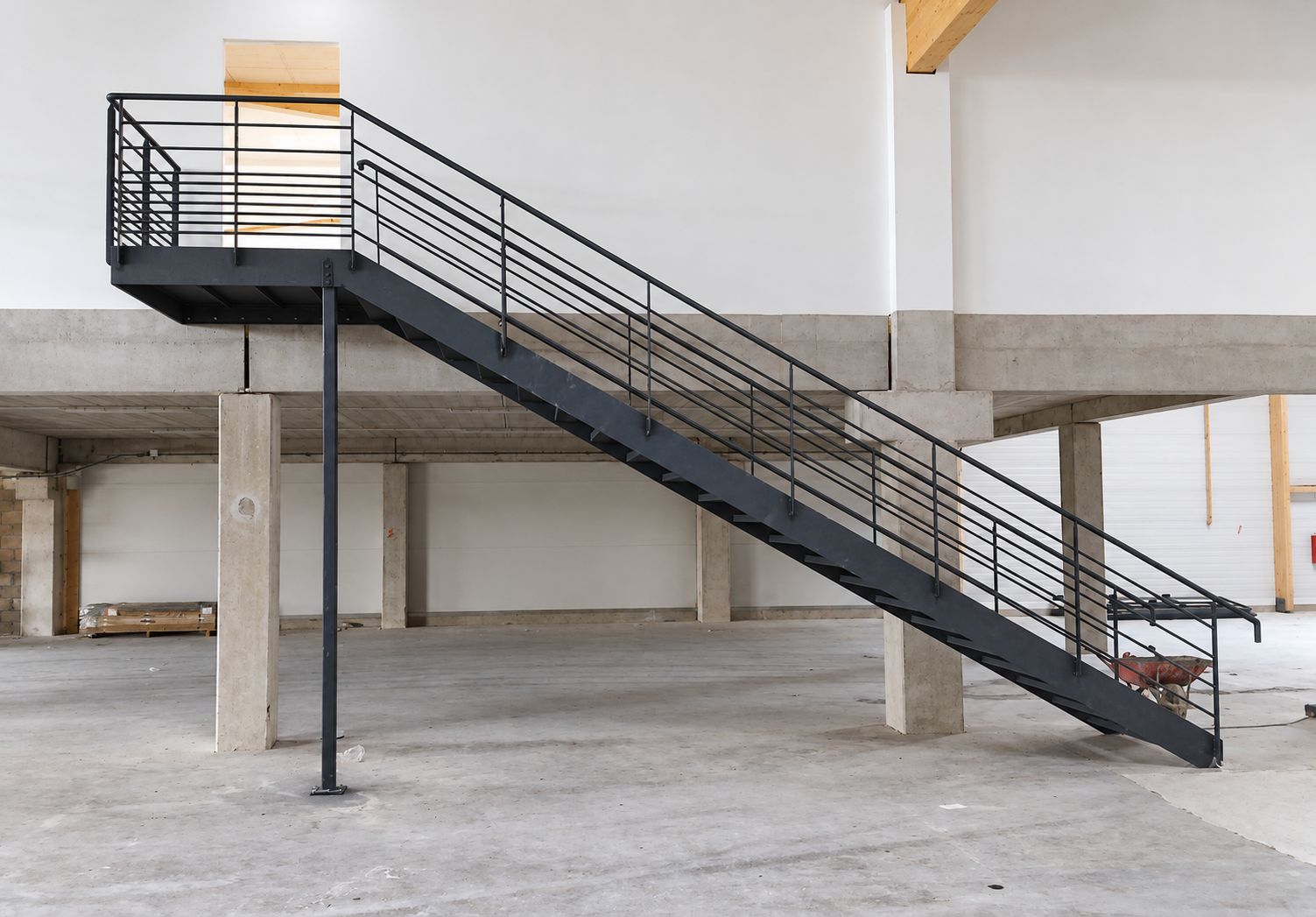 Escalier métallique avec palier et garde-corps dans un bâtiment industriel