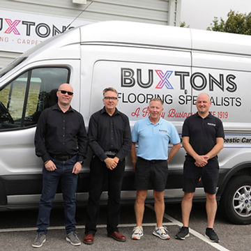 Four company directors posing in front of white Buxtons van
