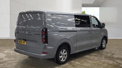 Rear offside view of grey Ford Transit Custom van in showroom setting