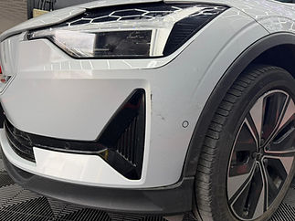 White car bumper restored with dent and bumper repairs techniques.