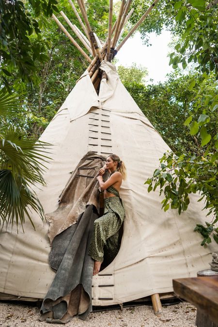 Guest seated inside a teepee-style retreat space.