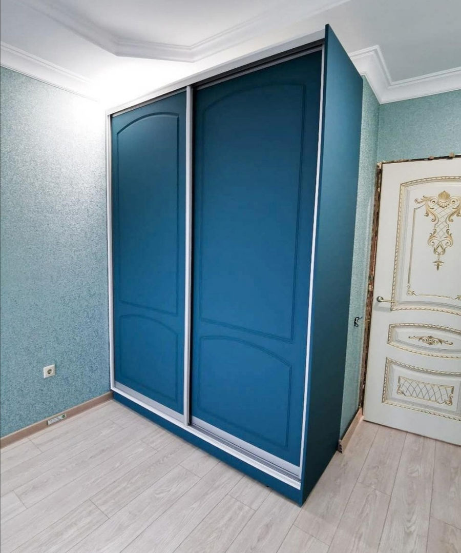 Синий шкаф-купе с раздвижными дверями в спальне
