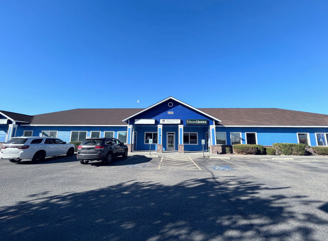 The outside of a large business complex 4 visible business entrances.