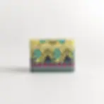 Small yellow tin box with teal and pink peacock pattern
