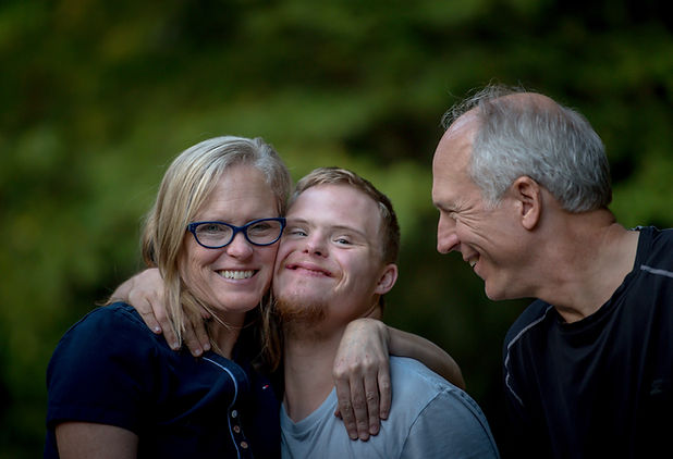 A teen smiles as their parents give a supportive hug. Teen counseling in Silverthorne, CO can offer similar support. Contact a teenage therapist for more info about teen counsleing in Summit County, CO and other services.