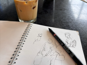 Coffee and a sketchbook with line drawings of people